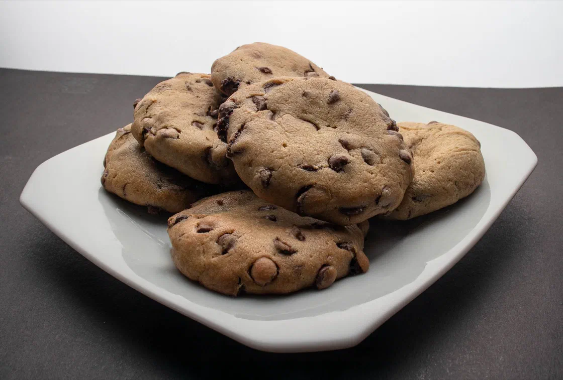 Une pile de cookies aux pépites de chocolat sur une assiette blanche