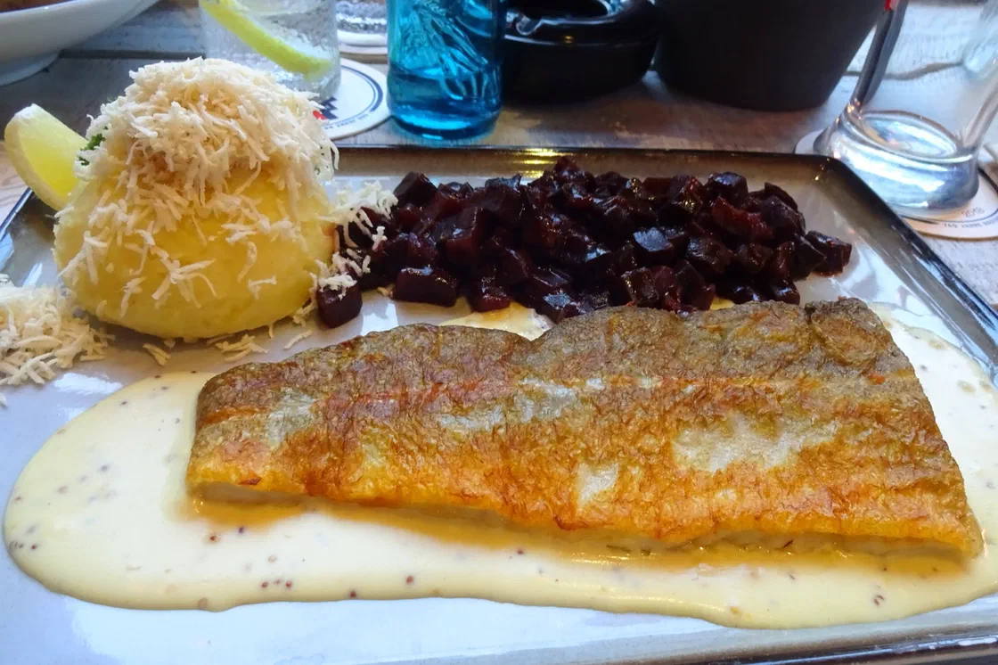 Filet de cabillaud poêlé côté peau, bien doré, posé sur une sauce crémeuse à la moutarde à l'ancienne, avec une purée et des dés de betterave
