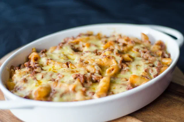 Gratin de pâtes au fromage fondu et doré dans un plat ovale blanc