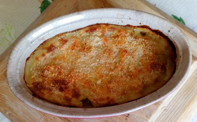 Hachis parmentier sortant du four dans un plat ovale, surface de purée dorée et gratinée